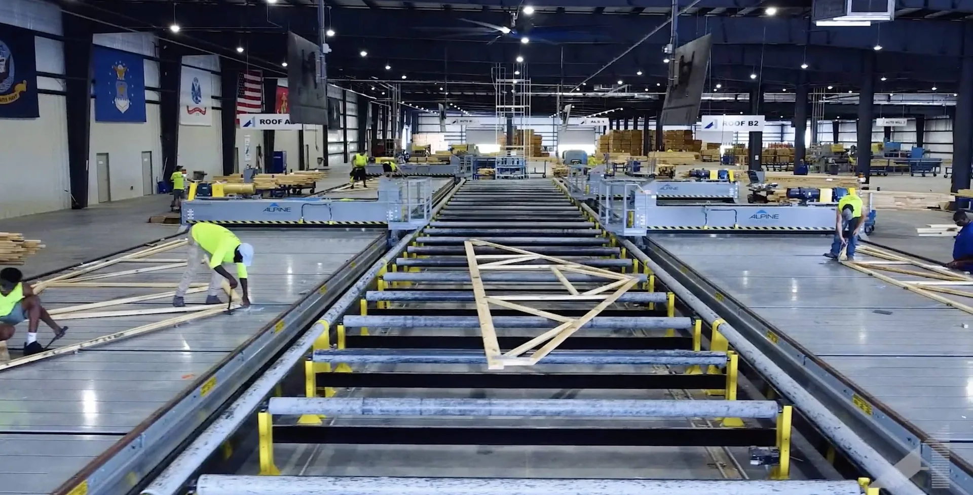 A-1 Components truss manufacturing floor with Alpine conveyor lines and workers assembling roof trusses