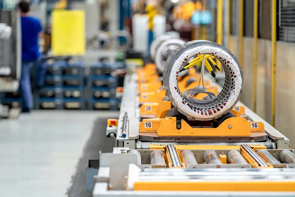 Electric motor parts on numbered conveyor stations representing PO lifecycle stages